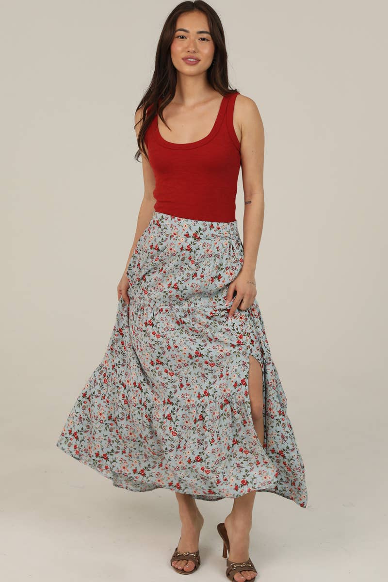 Woman wearing a red tank top and floral skirt on a beige background