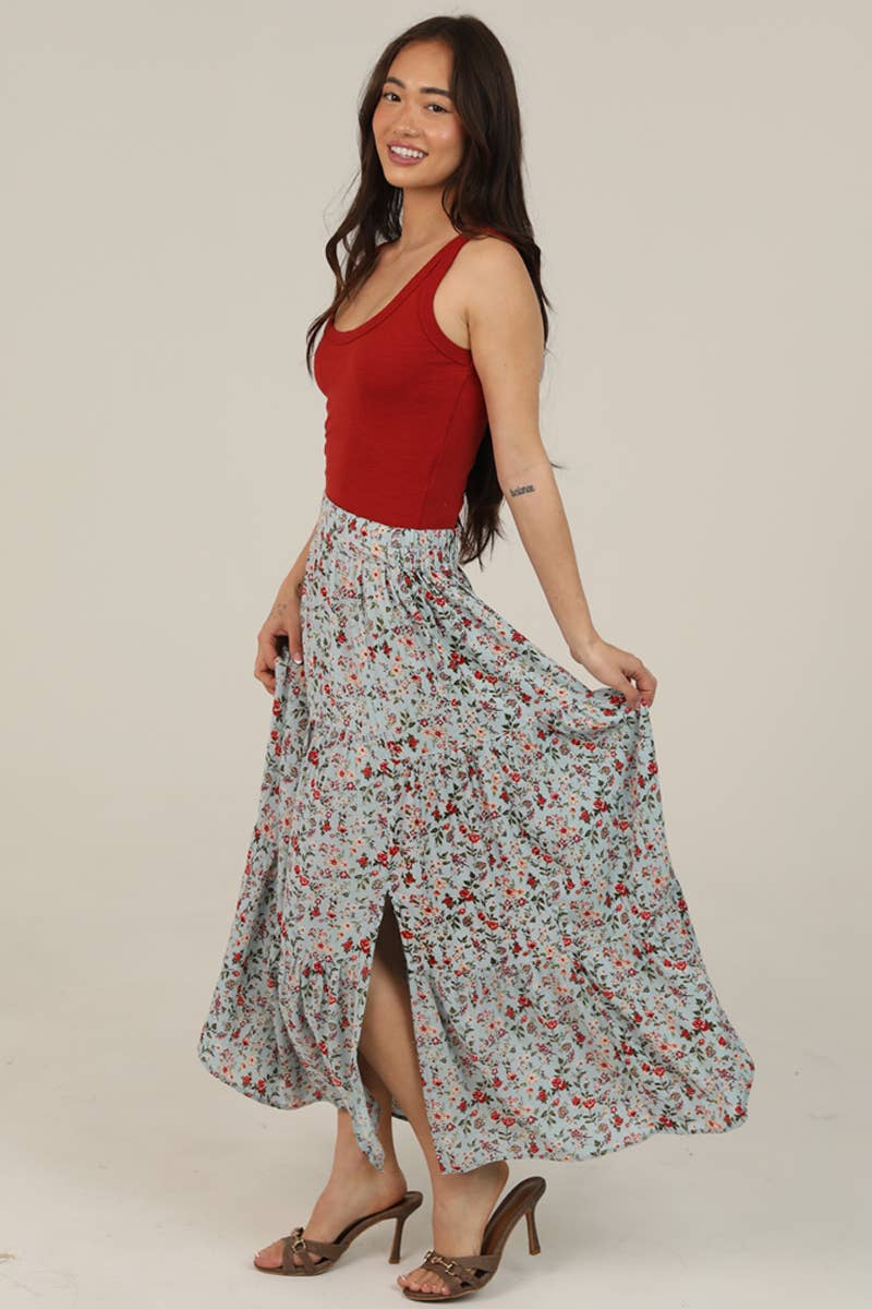 Woman wearing a red top and floral skirt on a beige background