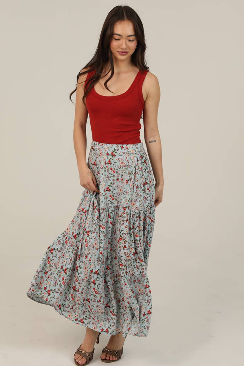 Woman wearing a red tank top and floral skirt on a beige background